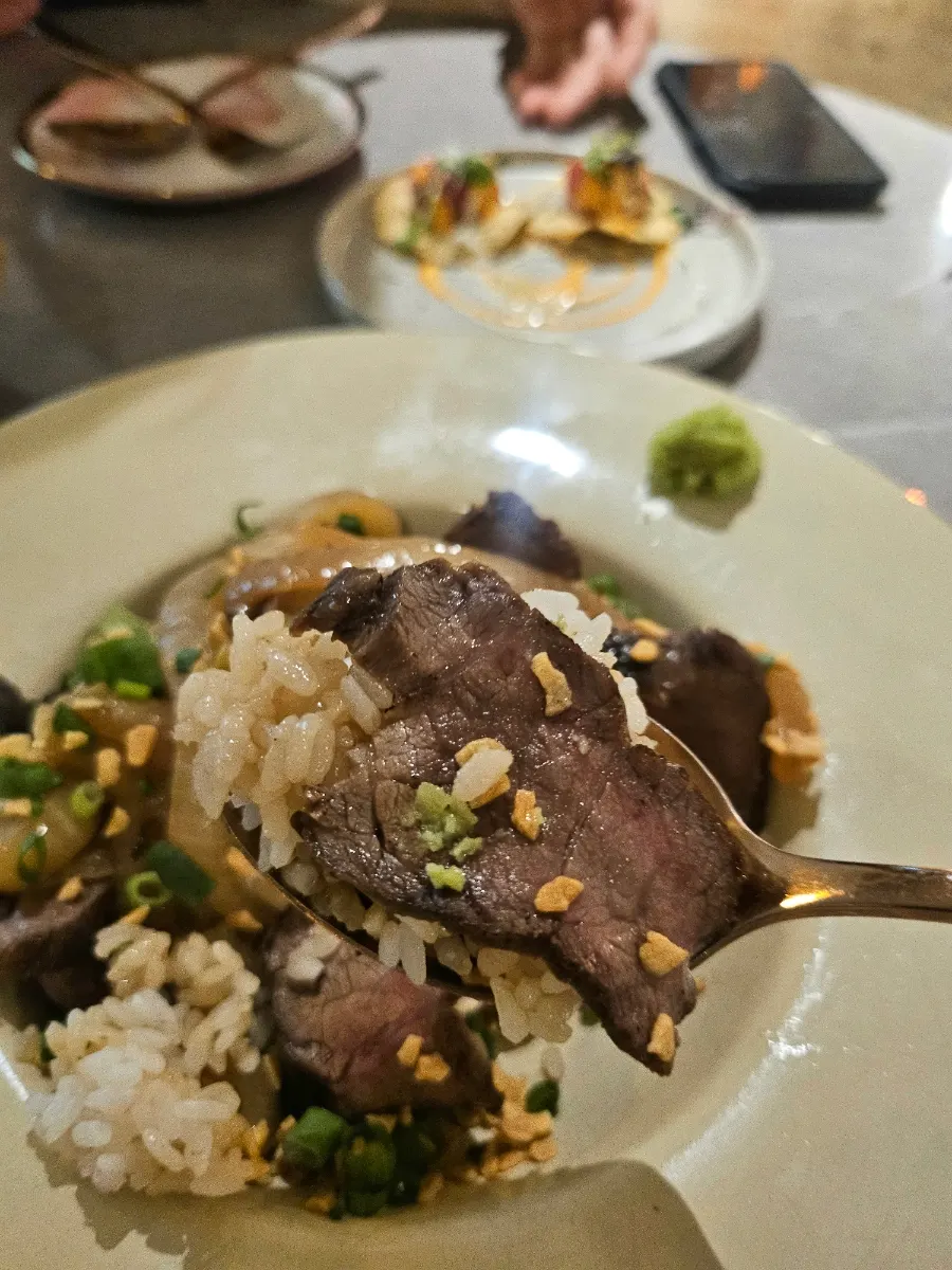 A bite of steak rice bowl with wasabi