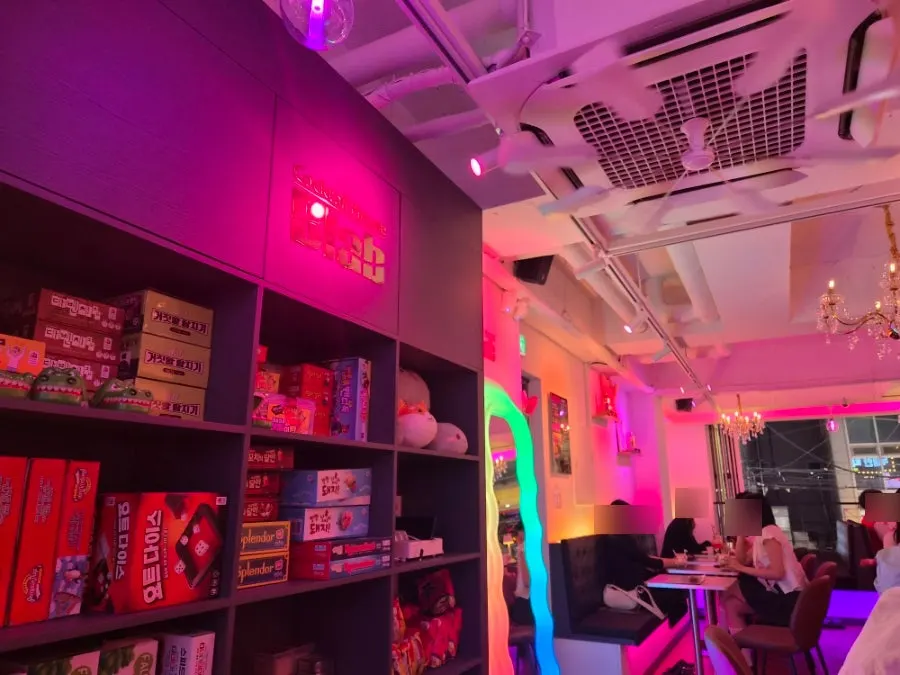 Interior of B-LAB with pink ambient lighting and a chandelier
