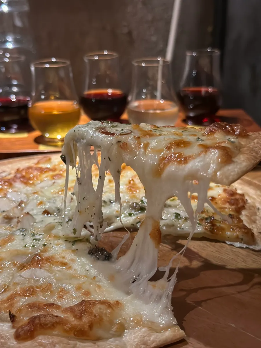 A slice of gorgonzola pizza with stretching cheese