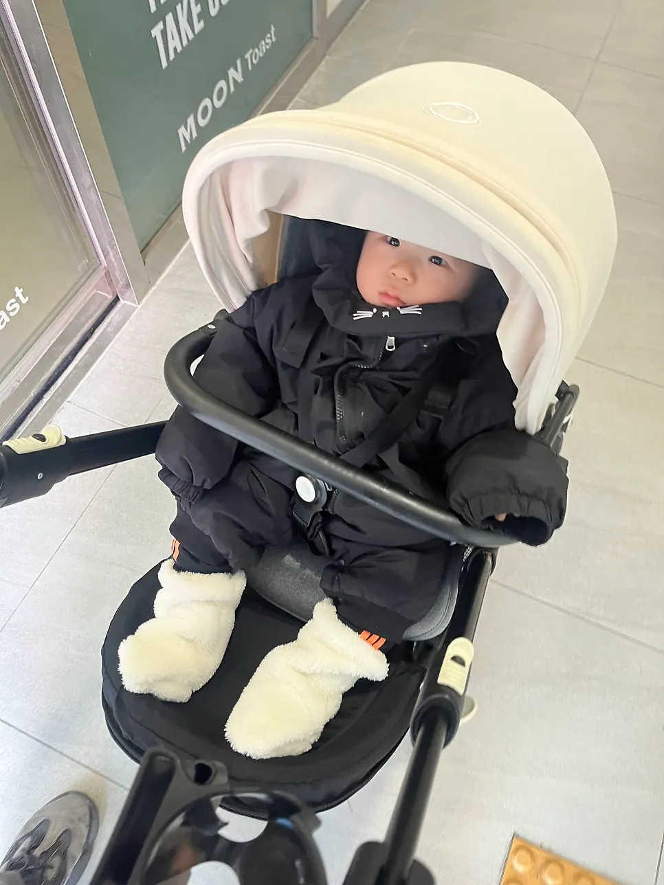 Baby foot warmers styled over a snowsuit