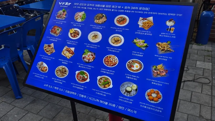 Menu board and outdoor tent seating in front of the restaurant