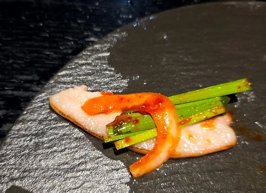 Pork jowl piled with chive salad