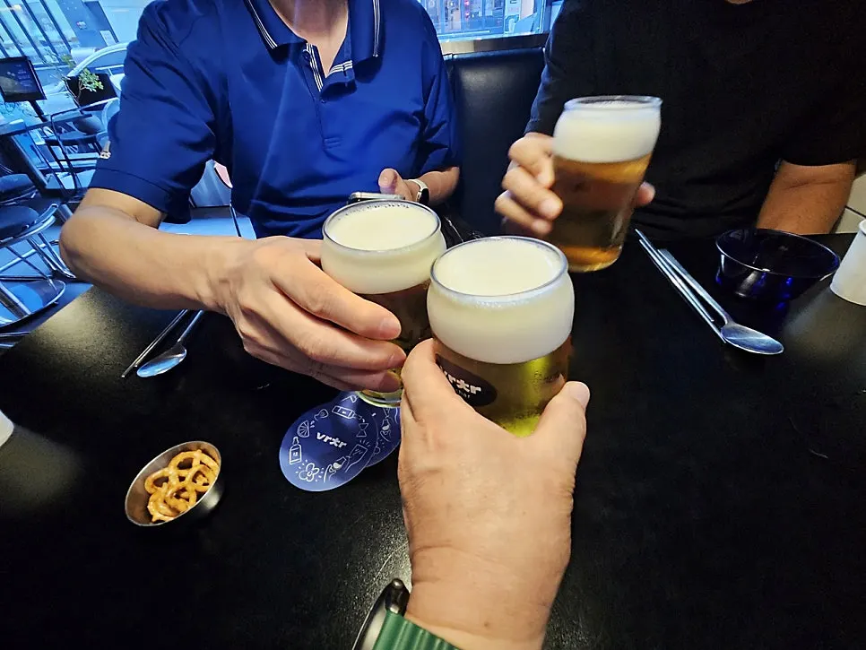 Friends clinking draft beer glasses together
