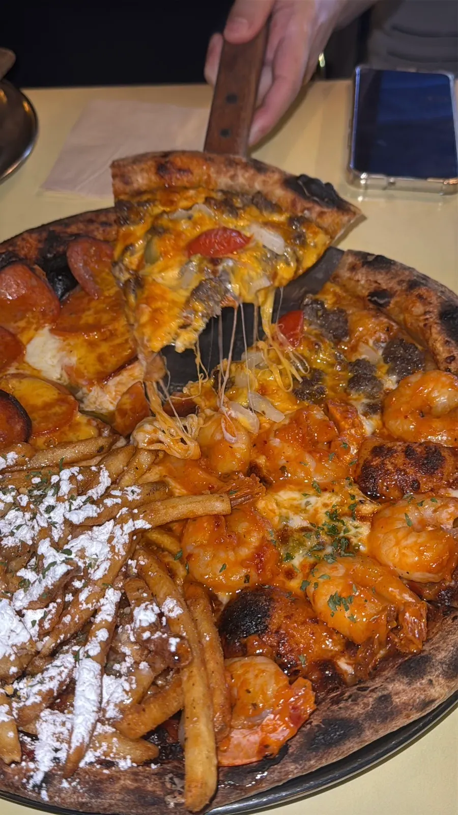 A slice of bulgogi pizza under dim lighting