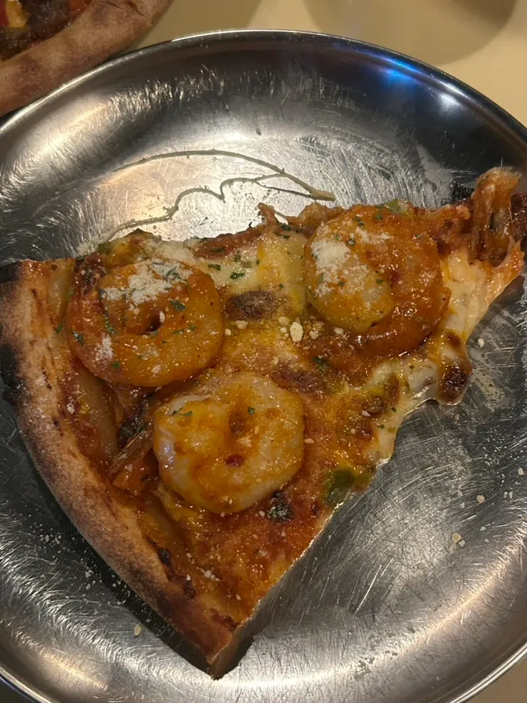 Pizza slice with pepperoni and shrimp toppings