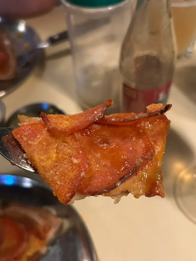 A slice of pizza enjoyed with beer