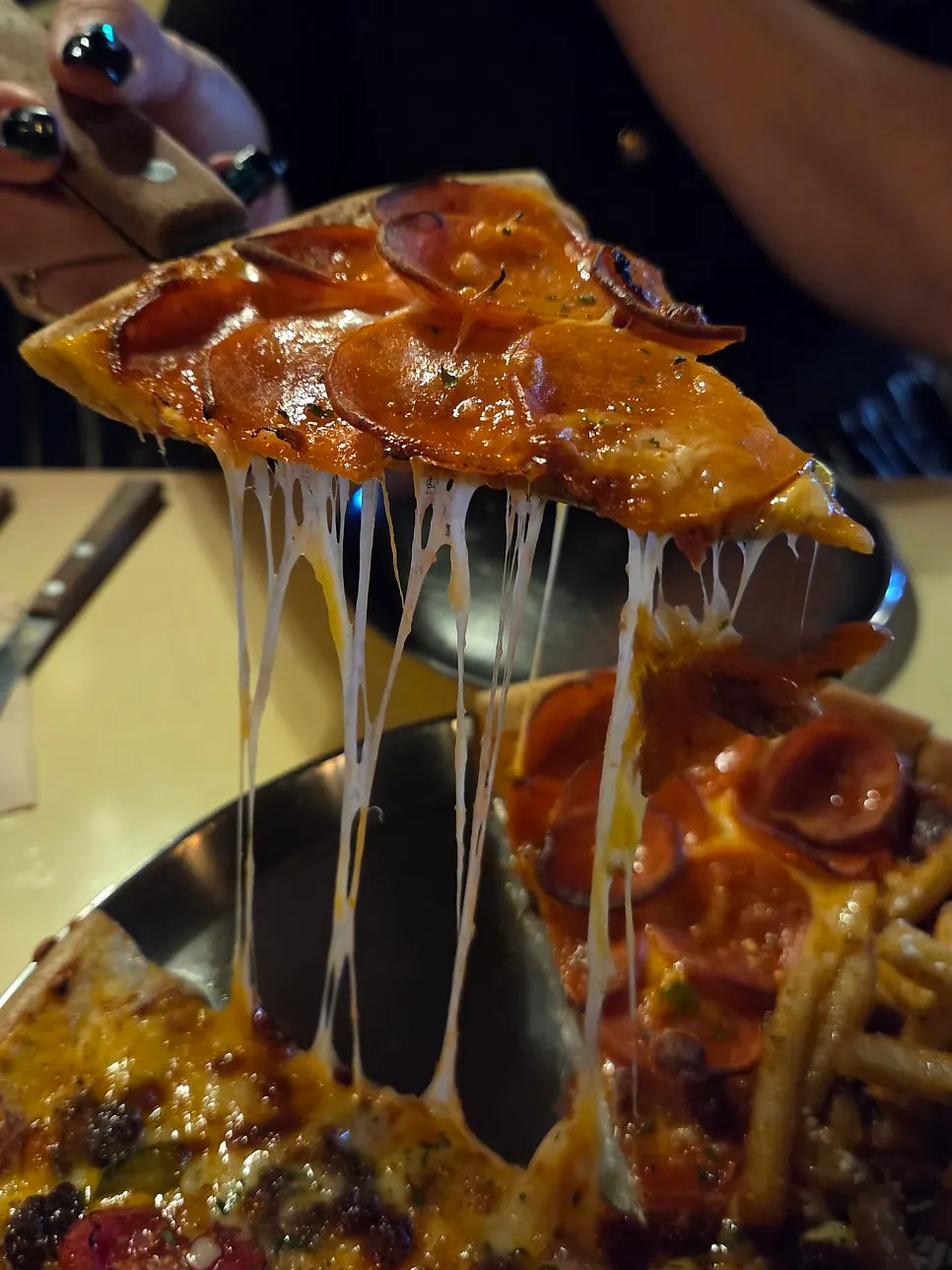 A pizza slice with cheese stretching out