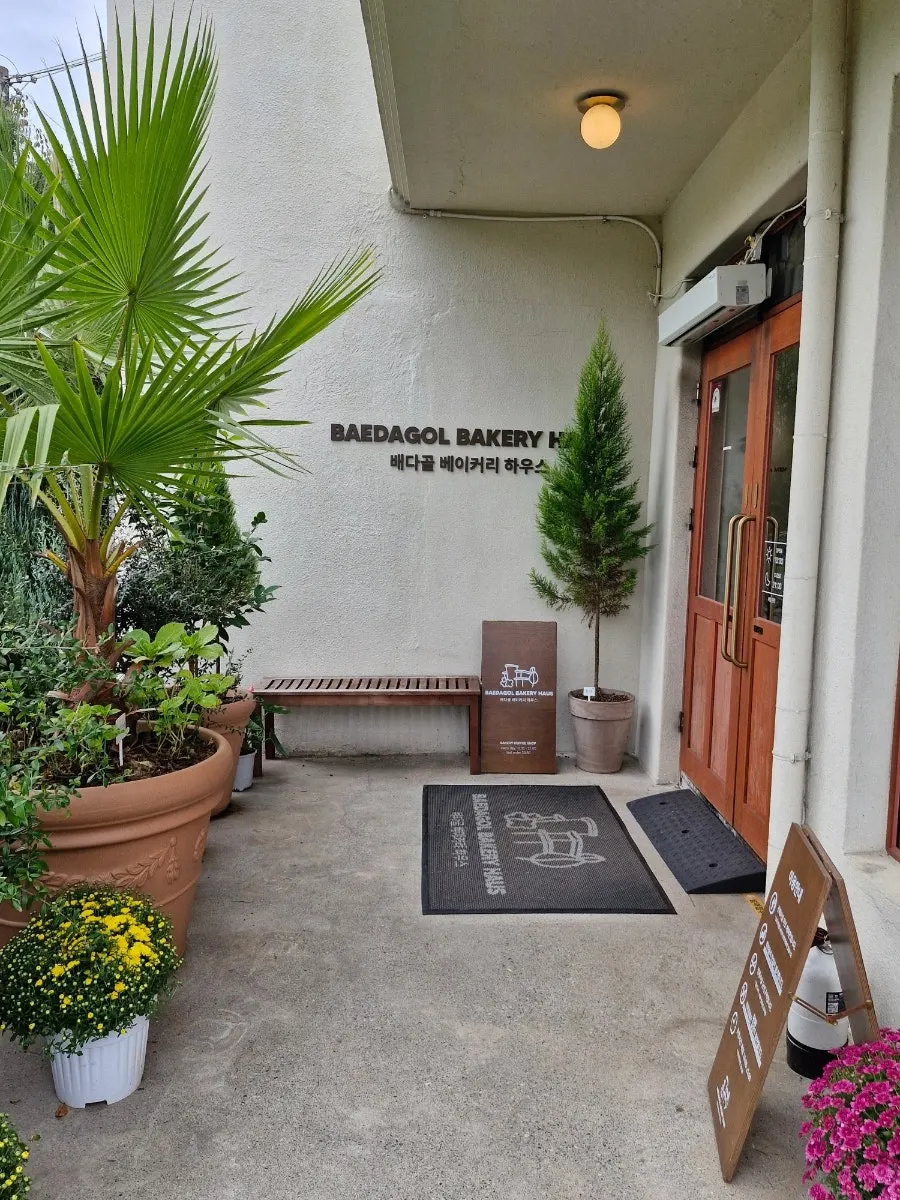 Exterior of Baedagol Bakery House with garden and trees visible