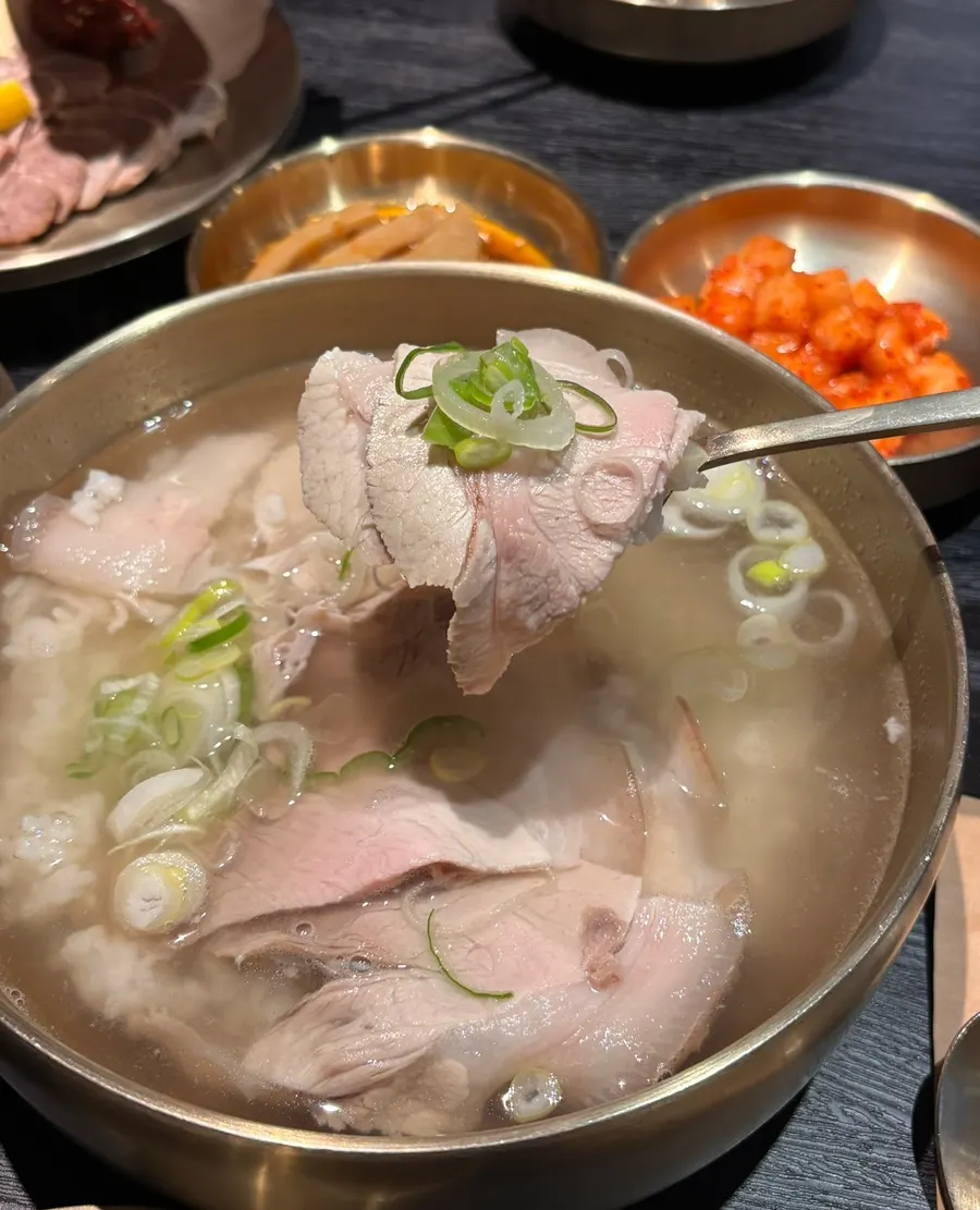 Pork gomtang topped with thinly sliced meat and scallions