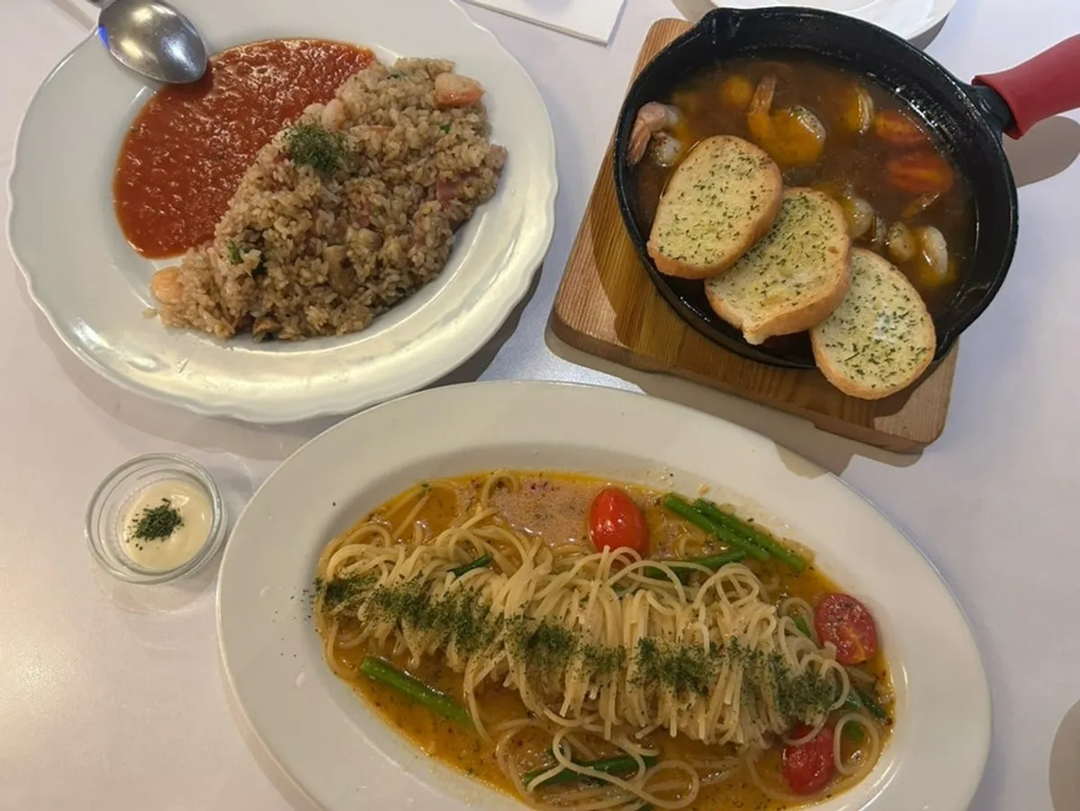 Aglio olio, shrimp pilaf, and gambas laid out together