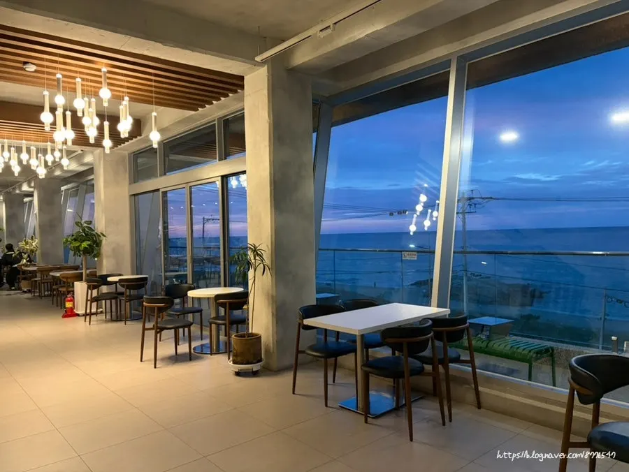 Upper floor interior at Baegya Coffee with large windows facing the sea