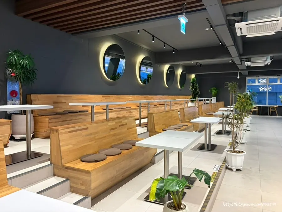 Spacious seating area in front of the large windows at Baegya Coffee