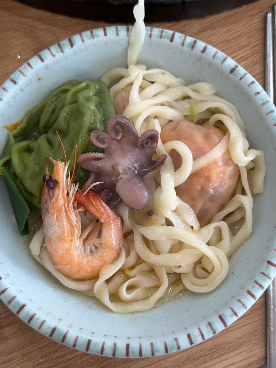 Broth with a large shrimp on top