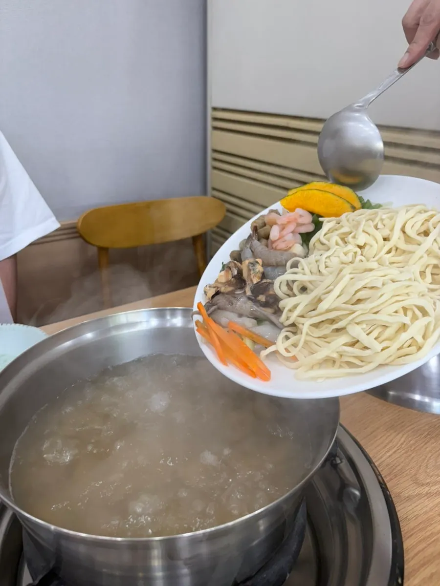 바지락 육수에 재료를 올린 해물칼국수 냄비