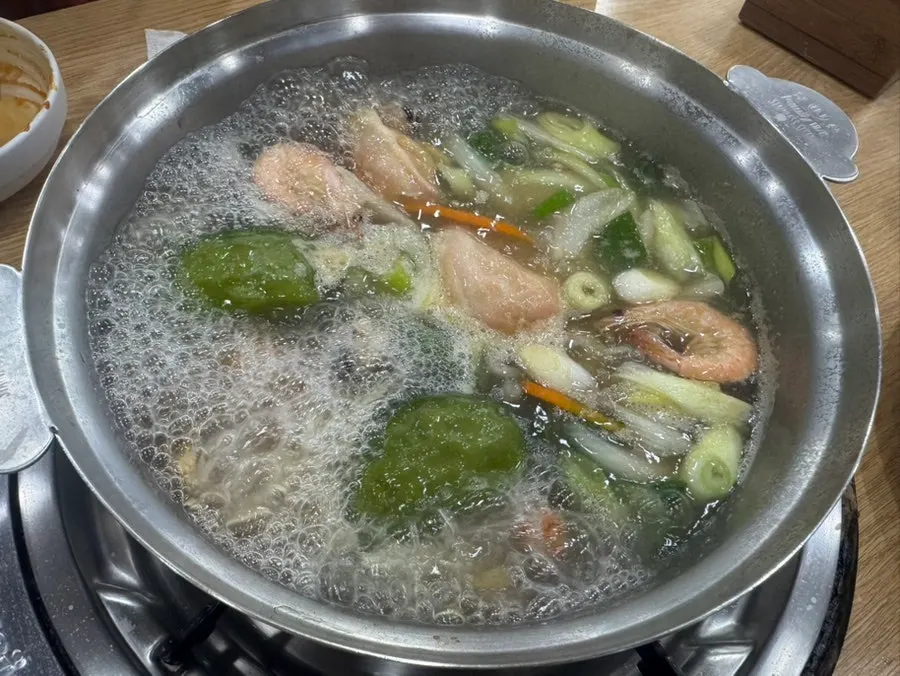 Adding kalguksu noodles into the hot pot