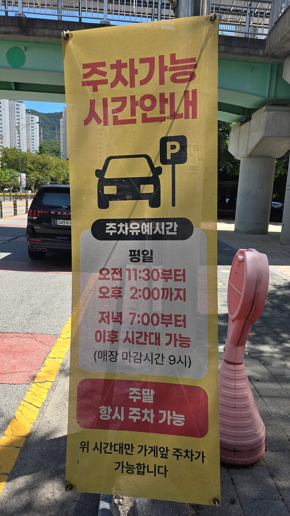 Banner in front of the shop showing parking hours