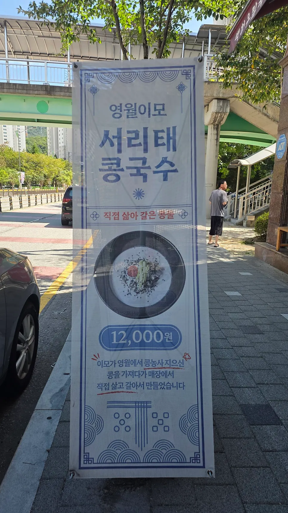 Banners for seasonal bibim noodles and black soybean noodle soup near the entrance