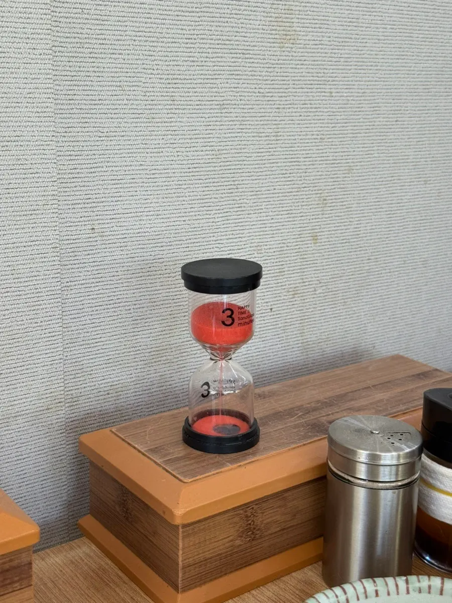 Seafood kalguksu pot boiling with the 3-minute hourglass beside it