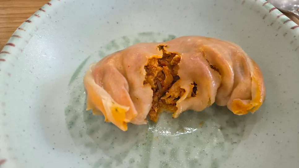 Chlorella meat dumpling split in half showing the filling