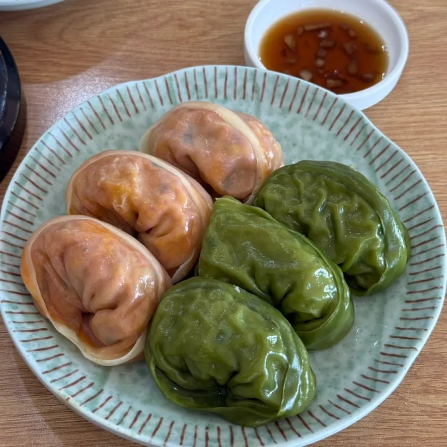 A plate of half kimchi, half meat steamed mandu