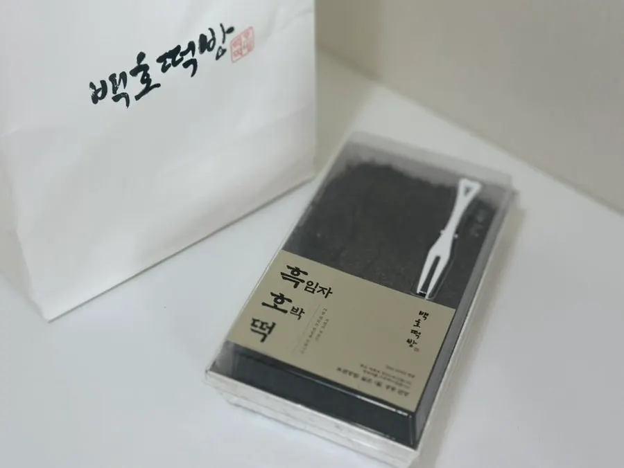 Two packs of black sesame and mugwort hoddeok side by side