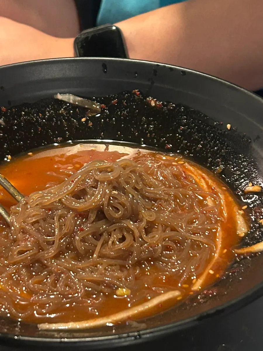A bowl of bibim naengmyeon partway eaten