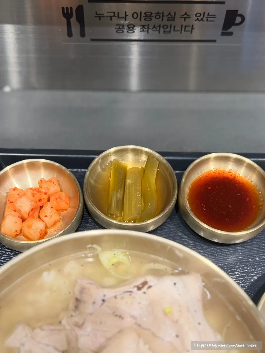 Table setting of the pork gomtang set with cabbage dumplings and a drink