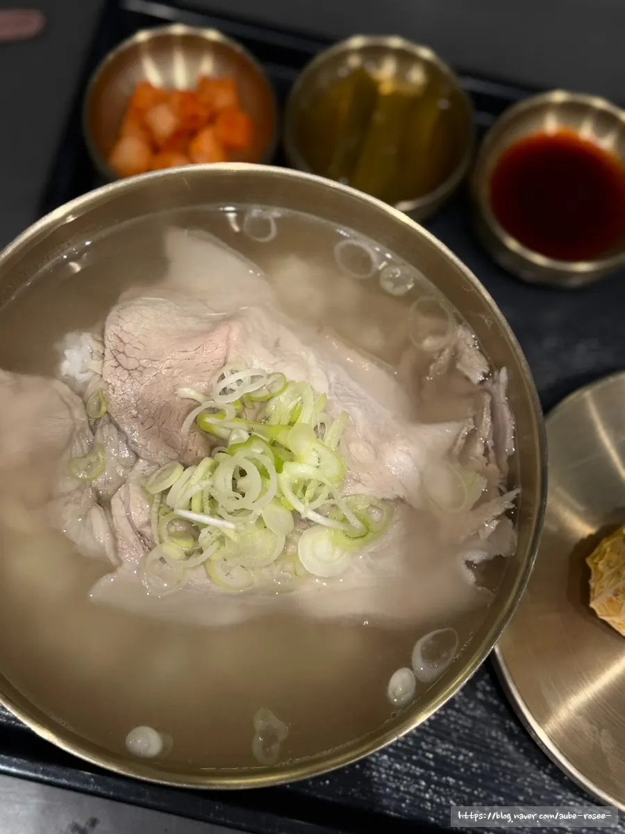 Pork gomtang served in a brass bowl topped with scallions