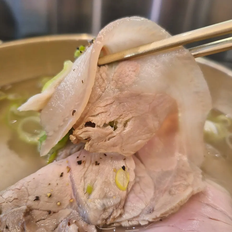 A spoonful of gomtang with pepper sprinkled on the meat
