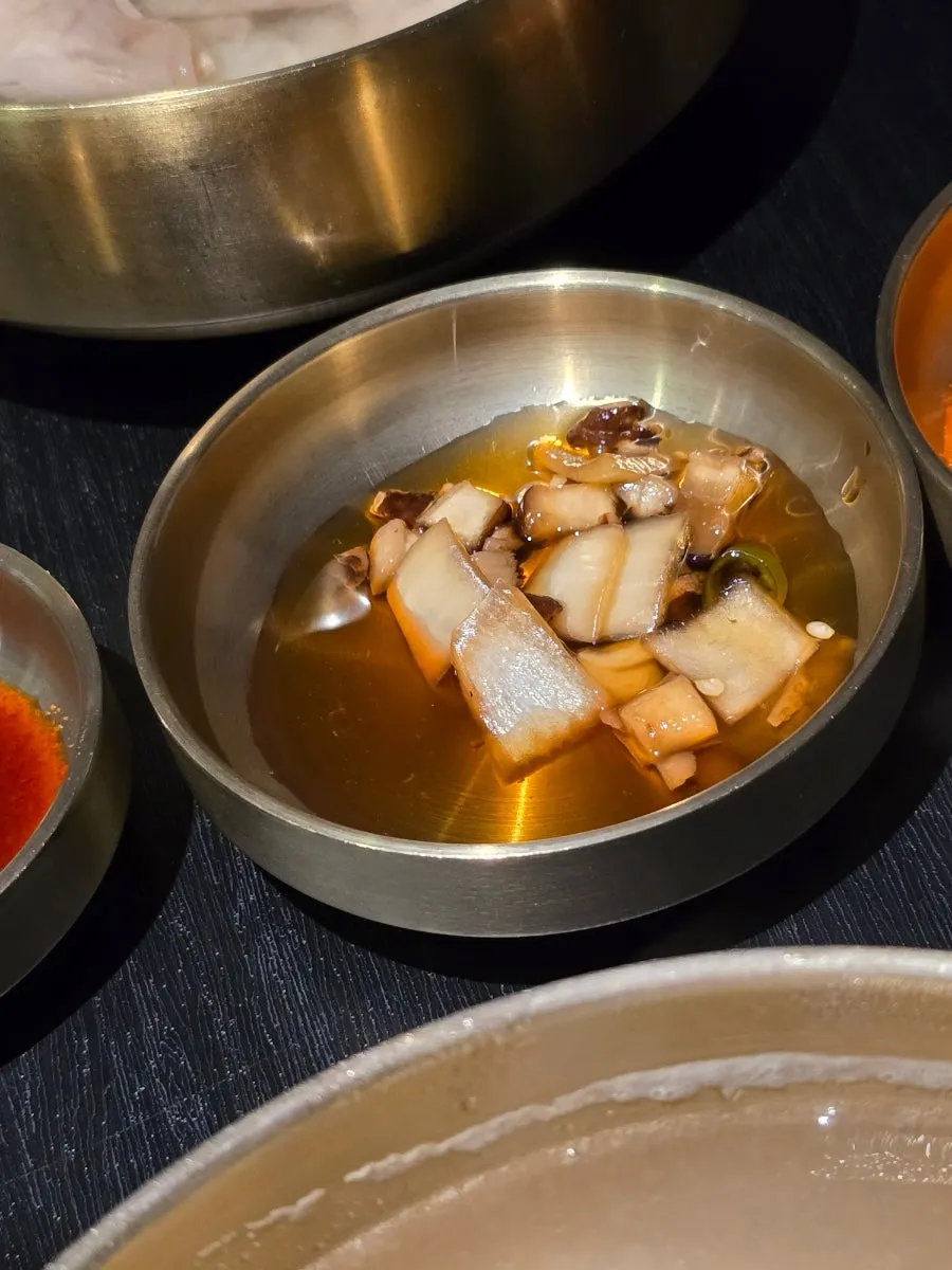 A plate of cabbage mandu served alongside gomtang