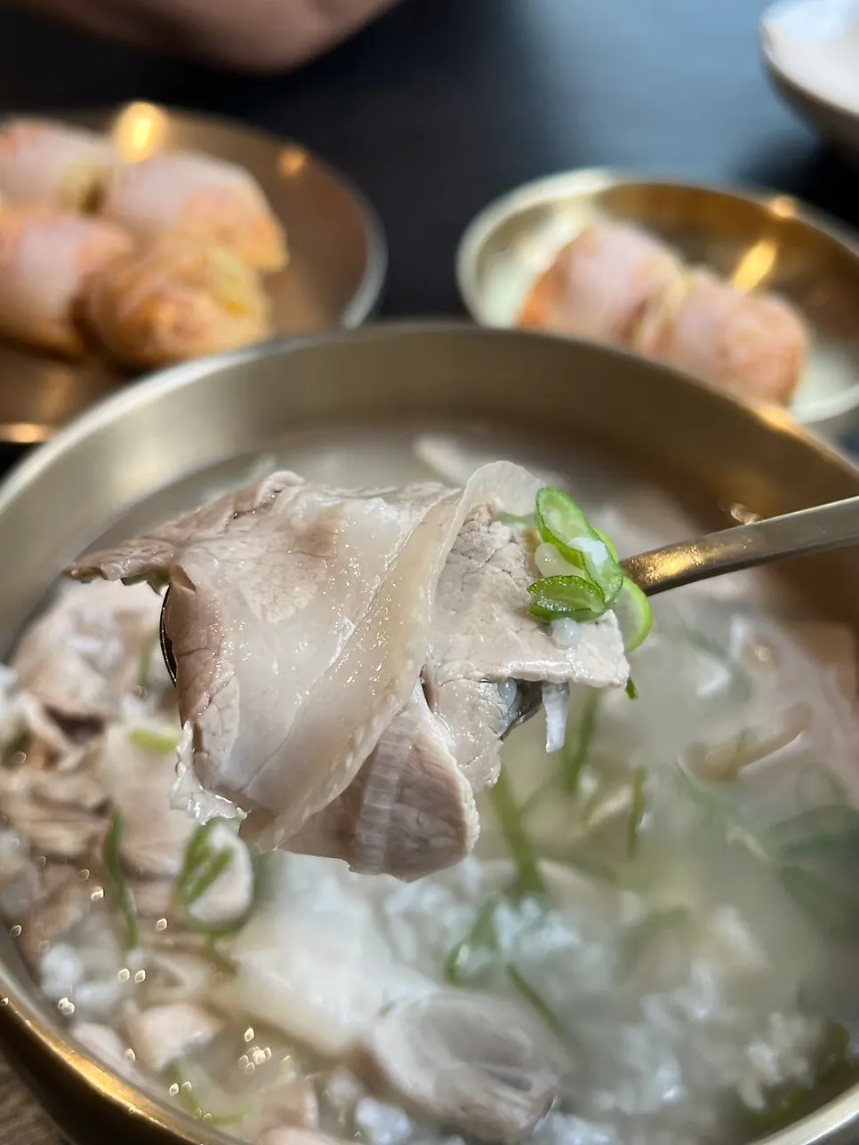 A spoonful of pork gomtang broth and meat