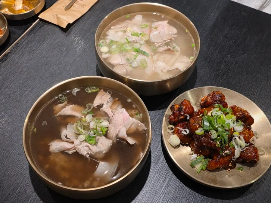 Table spread of pork gomtang and spicy pig tail at Baekok Yongsan