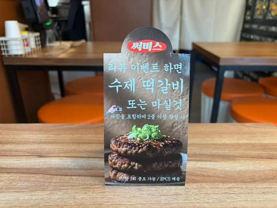 Sign explaining the review event choice between tteokgalbi and a drink