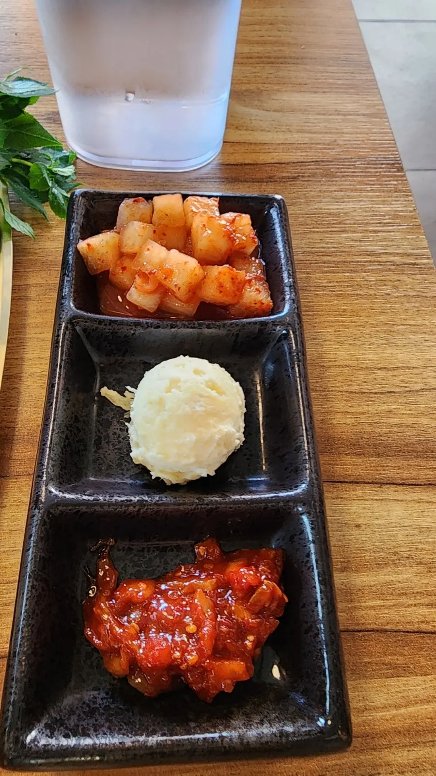 포장된 수저와 밑반찬 3종이 놓인 테이블