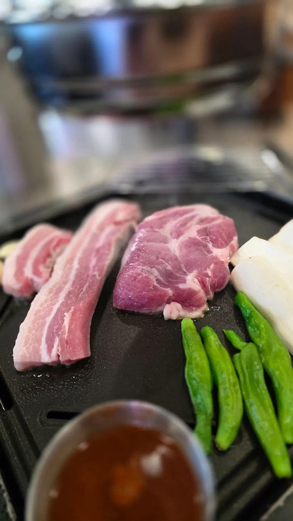 Vertical shot of meat and side dishes at Baeksan Hwarro Songjeol Branch