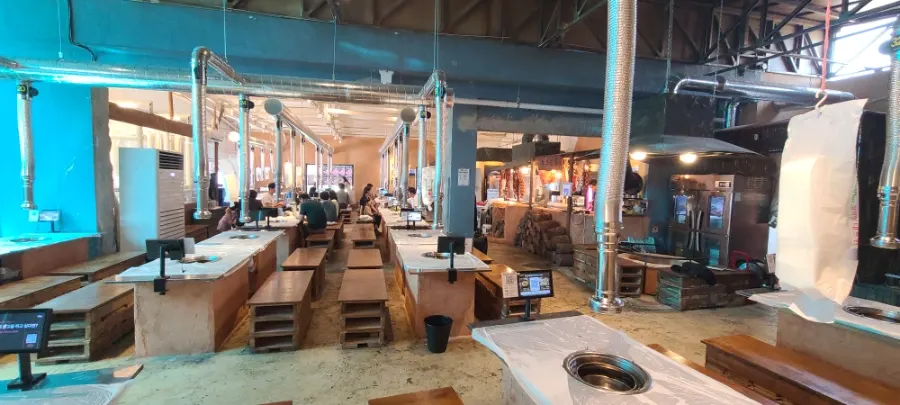 Interior with wooden chairs and mud-wall-style tables