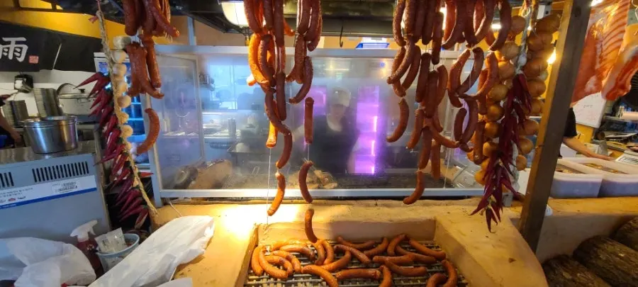 Meat and sausages hanging in front of the kitchen