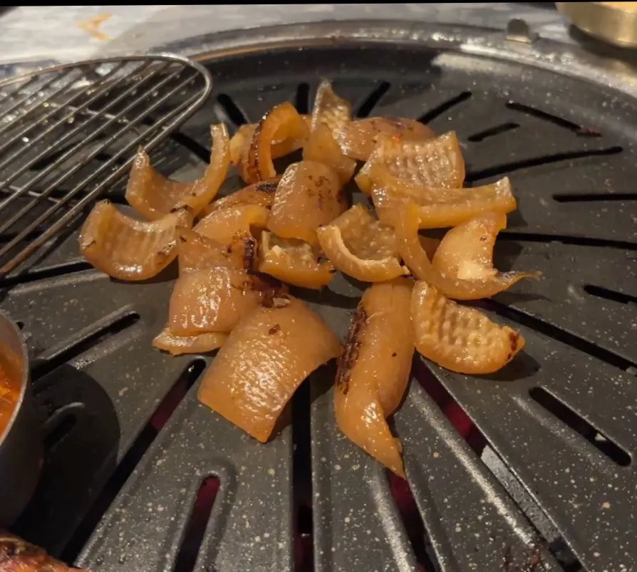 Raw galbi on the grill plate with side dishes