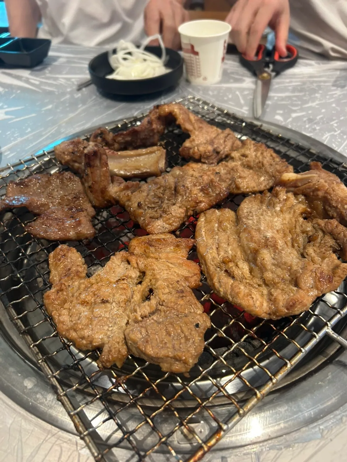 Seasoned pork galbi placed on the charcoal grill