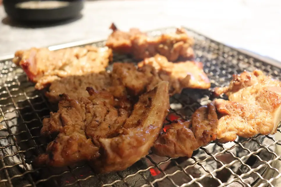 쌈에 올린 숯불 돼지갈비 한 점