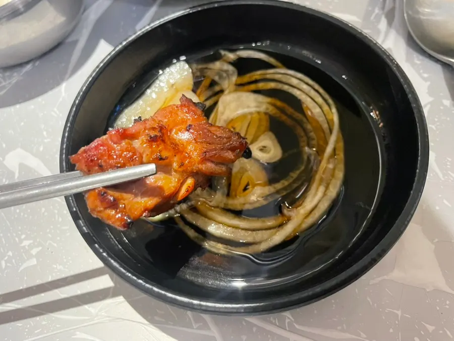 A piece of pork galbi wrapped in a vegetable leaf