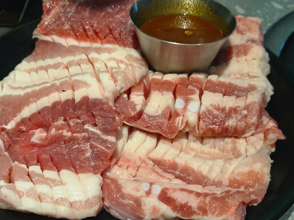Jinjja pork galbi grilling over charcoal