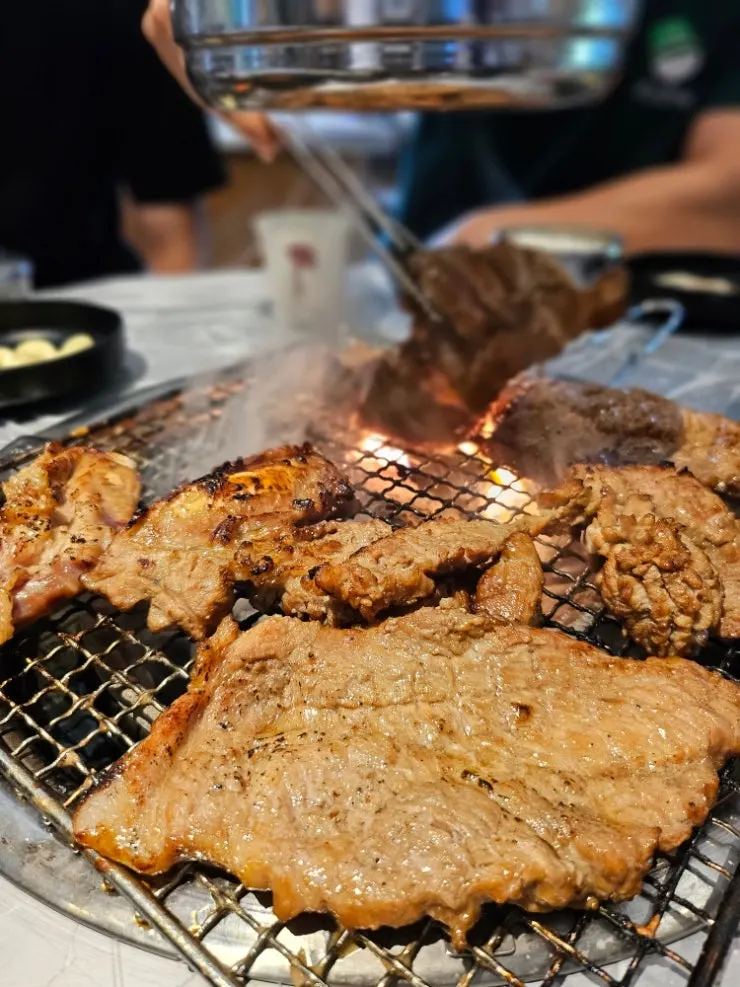 Pre-grilled pork galbi cooking over charcoal