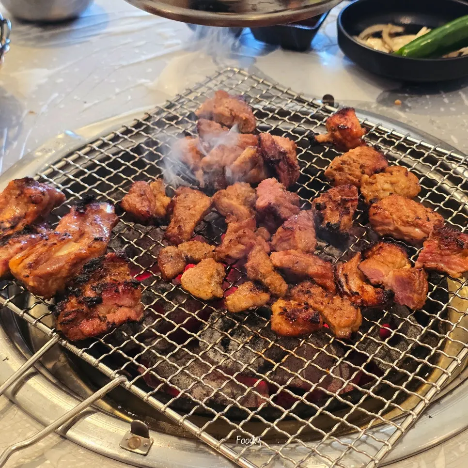 Half the seasoned galbi set aside in a bowl, grilled slowly