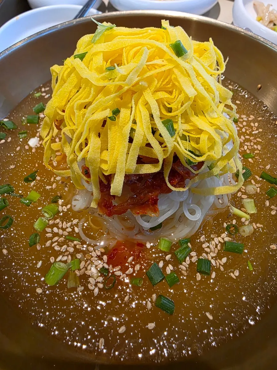 Noodles topped with kimchi and egg strips
