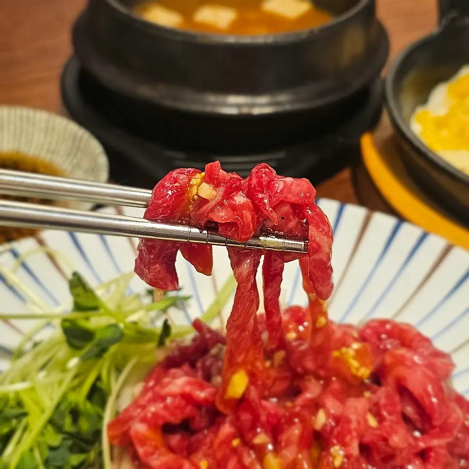 Yukhoe served over shredded radish and sprouts