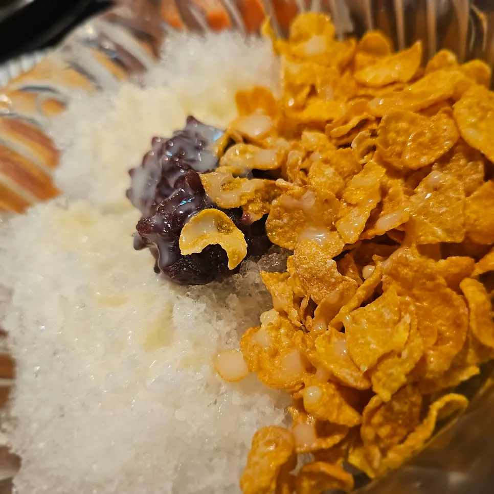 Close-up of bingsu topped with corn flakes and red beans