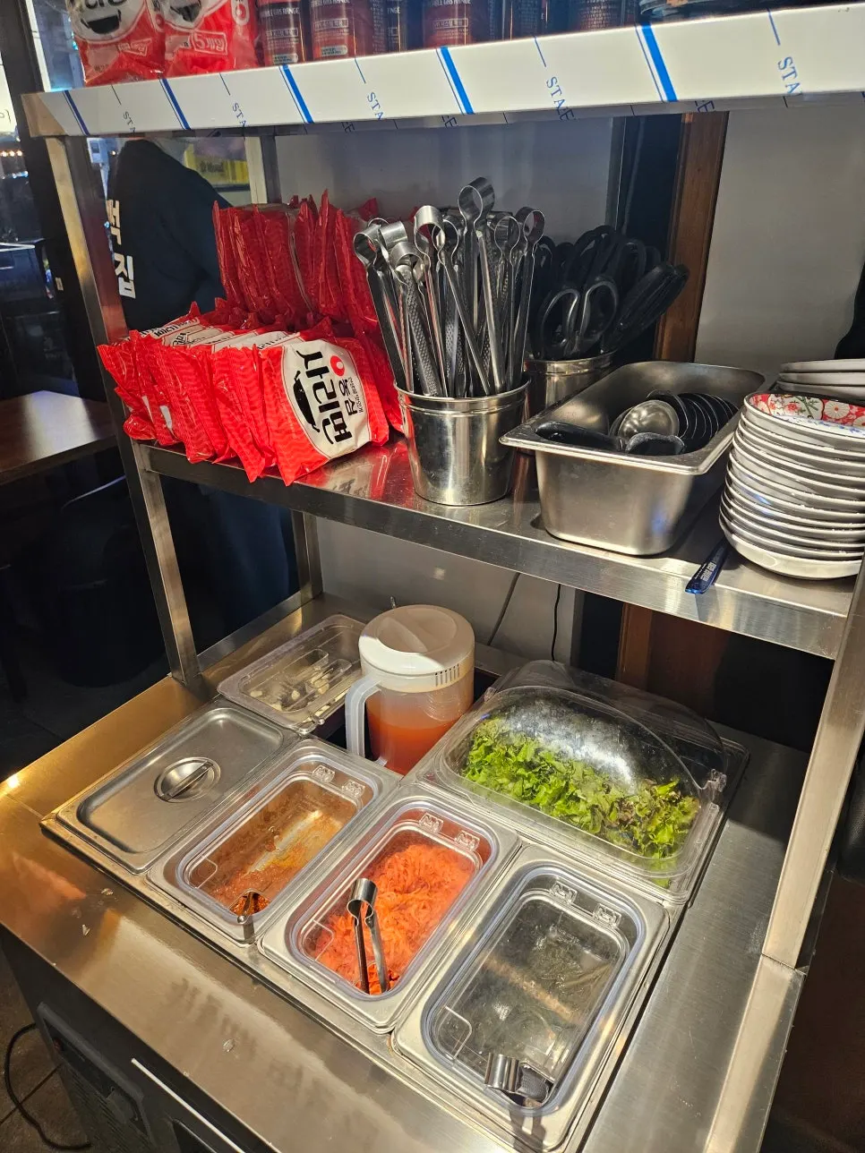 Self-serve bar at Baekseok Kkogijip with lettuce and side dishes