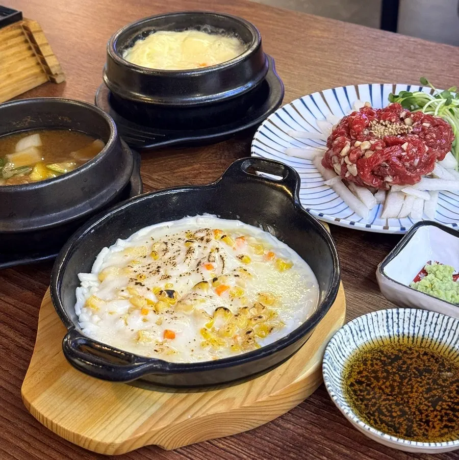 Table spread with soybean paste risotto, steamed egg, and corn cheese
