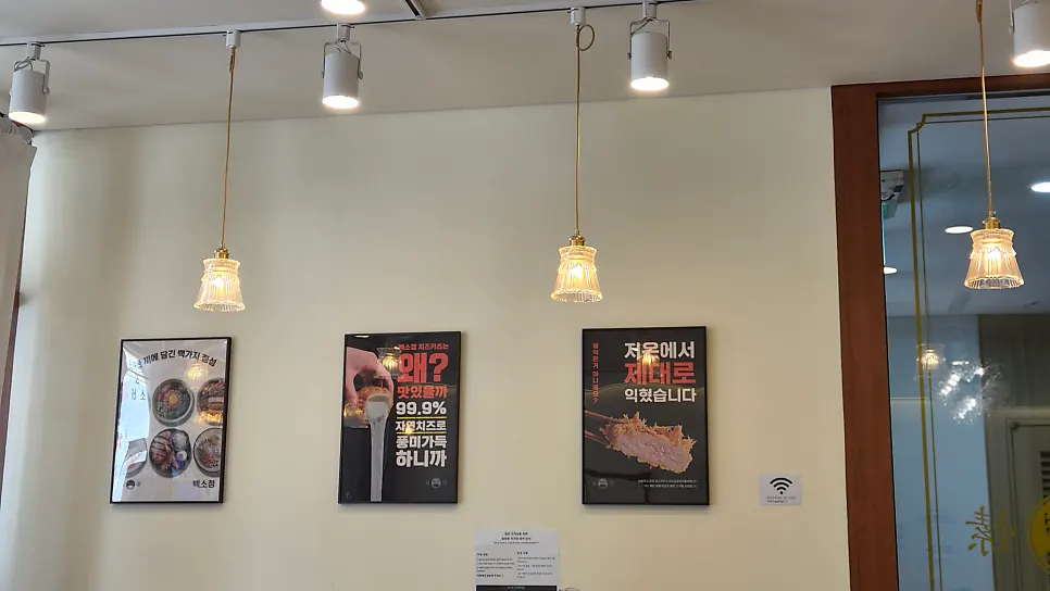 Glass-shade lighting and menu promotional posters on the wall